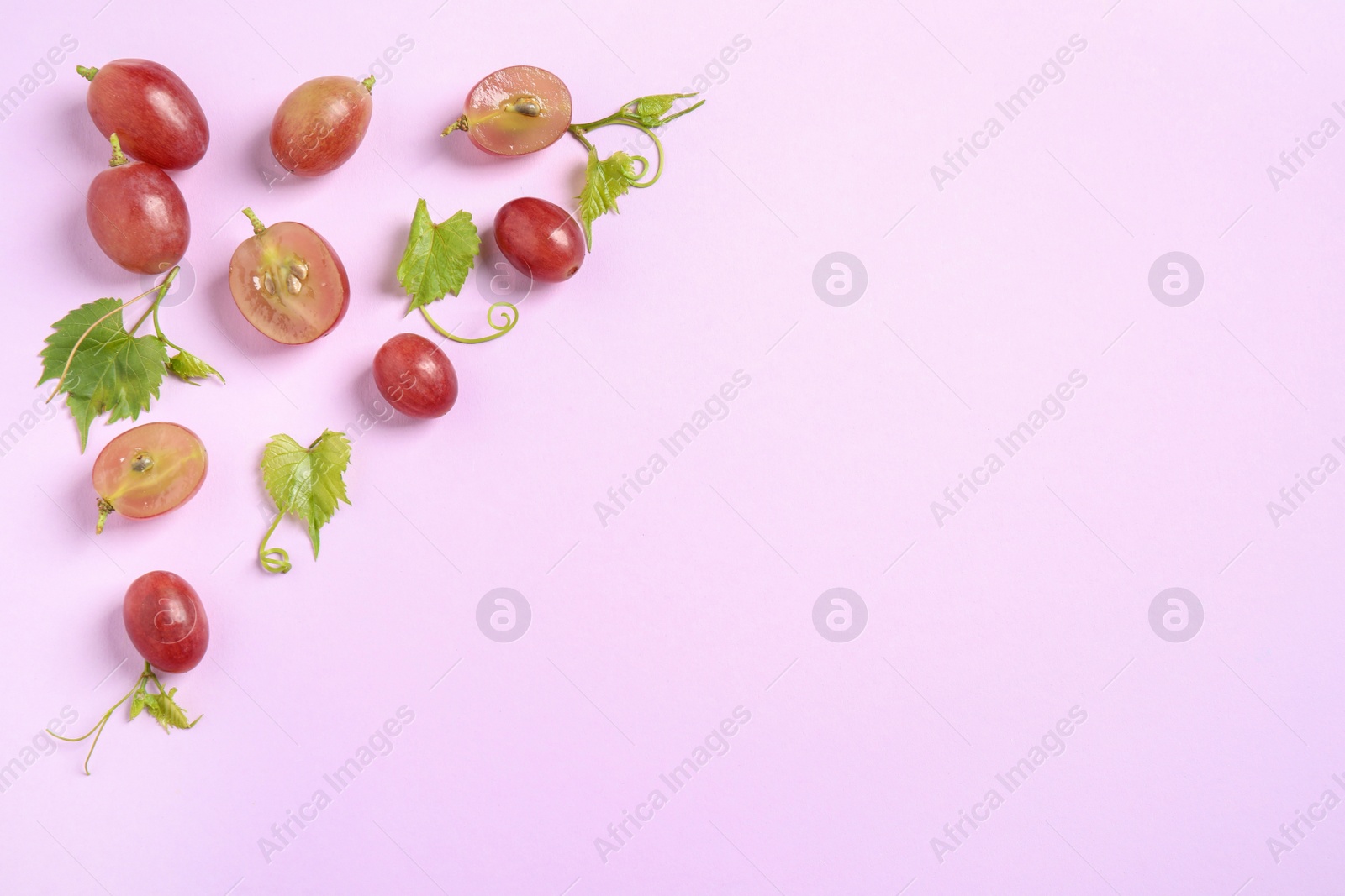 Photo of Flat lay composition with fresh ripe juicy grapes on lilac background, space for text
