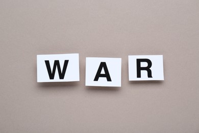 Photo of Word War made of cards with letters on grey background, top view
