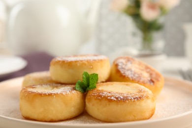 Photo of Delicious cottage cheese pancakes with mint and icing sugar on plate, closeup