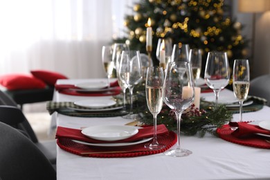 Photo of Christmas table setting with festive decor and dishware indoors