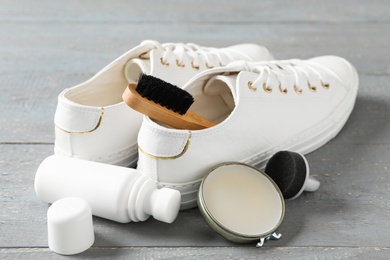 Photo of Composition with stylish footwear and shoe care accessories on grey wooden background
