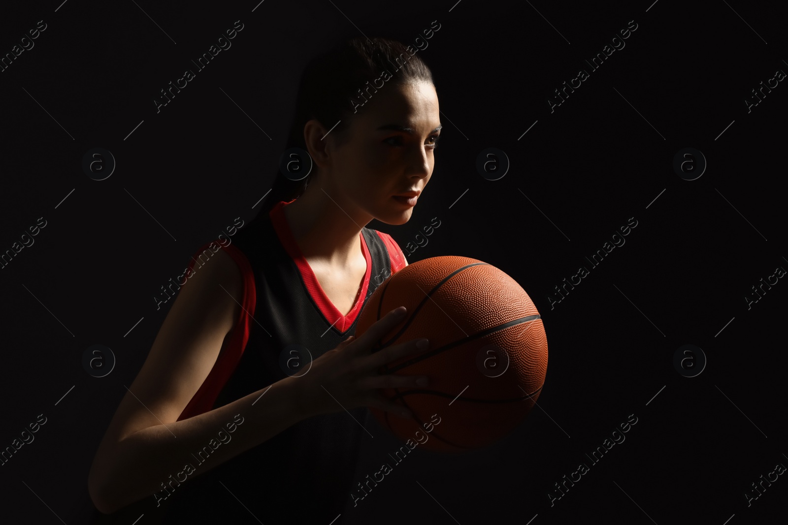 Photo of Basketball player with ball on black background