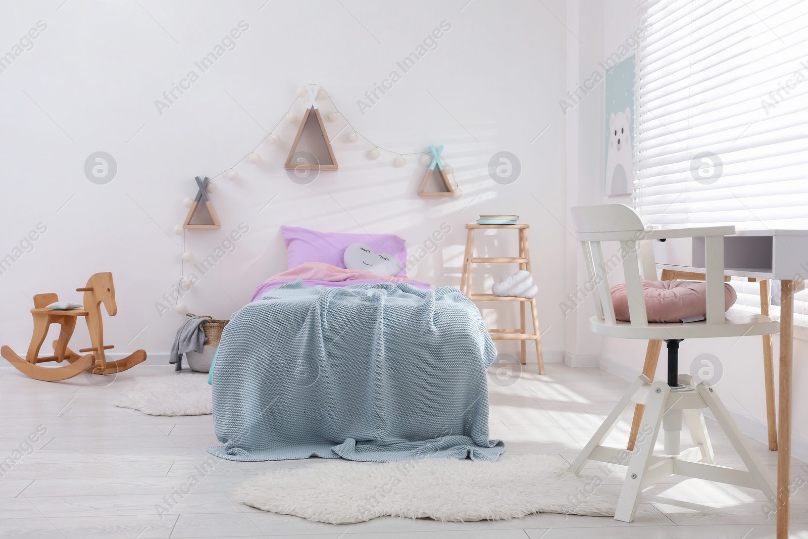 Photo of Comfortable bed with pink linens in children's room