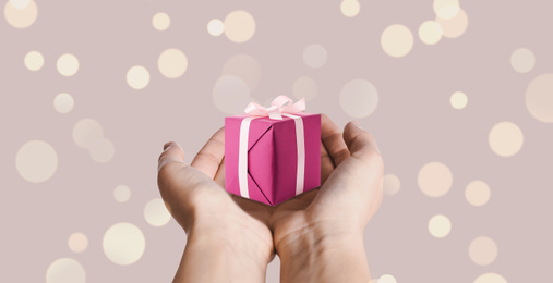 Image of Boxing day, banner design. Woman with gift on beige background, closeup