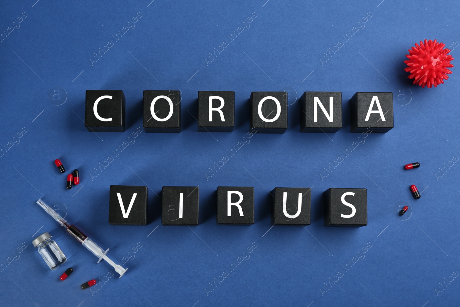 Photo of Wooden cubes with words CORONA VIRUS and medicine on blue background, flat lay