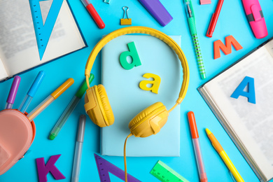 Flat lay composition with books and stationery on light blue background