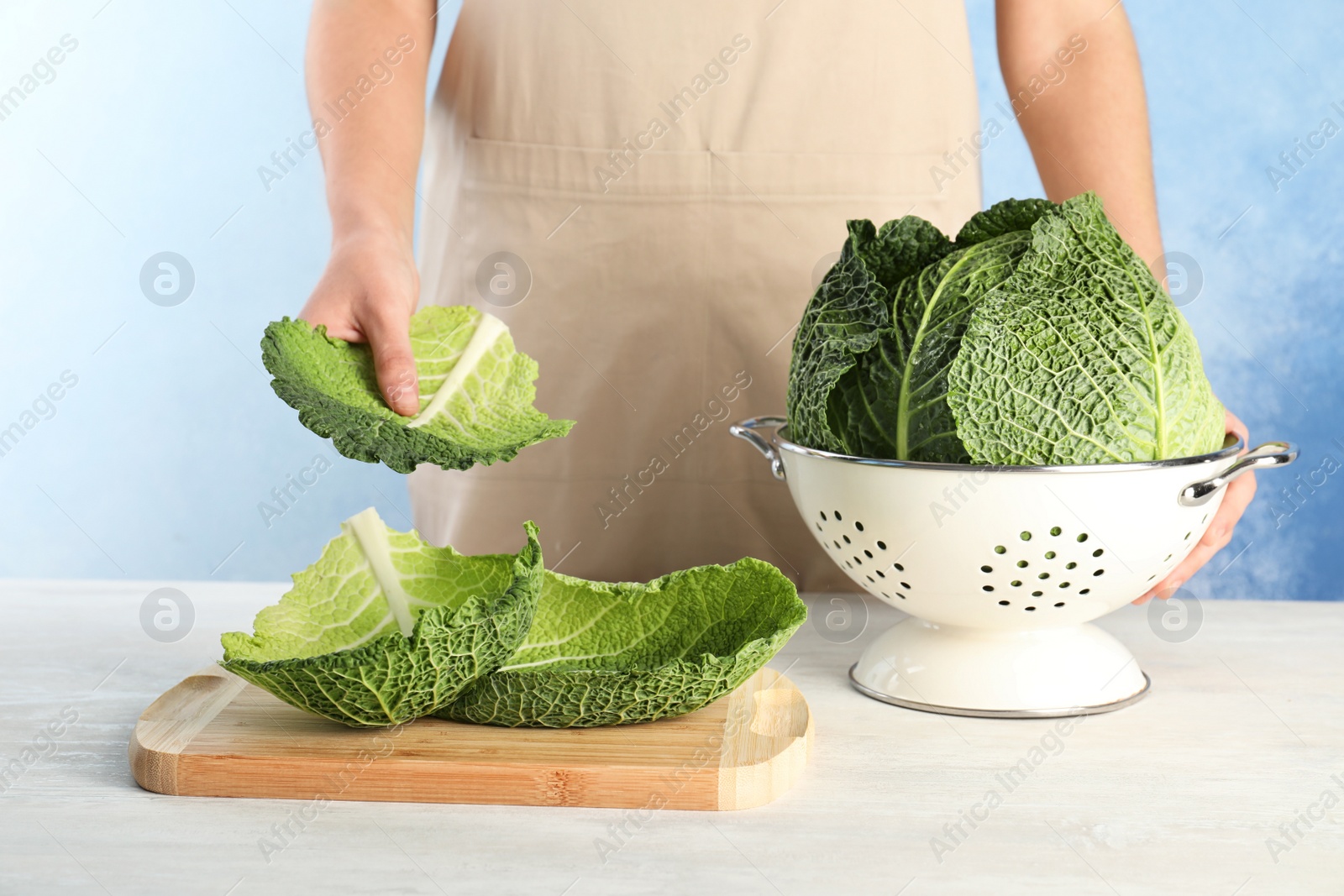 Photo of Woman with fresh savoy cabbage at table