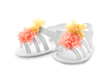 Photo of Pair of baby sandals decorated with flowers on white background