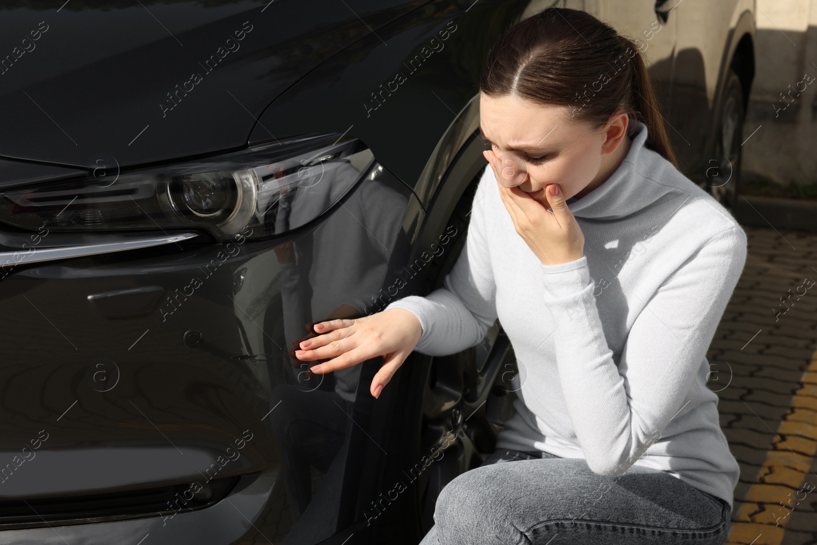 Photo of Stressed woman near car with scratch outdoors