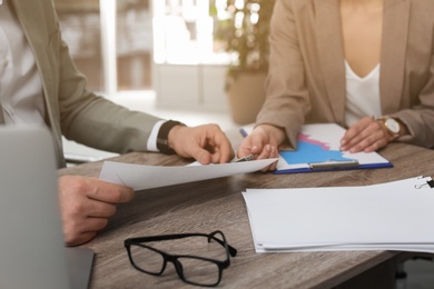 Photo of Office employees working with documents at table, closeup