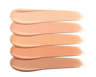 Different shades of liquid skin foundation on white background, top view