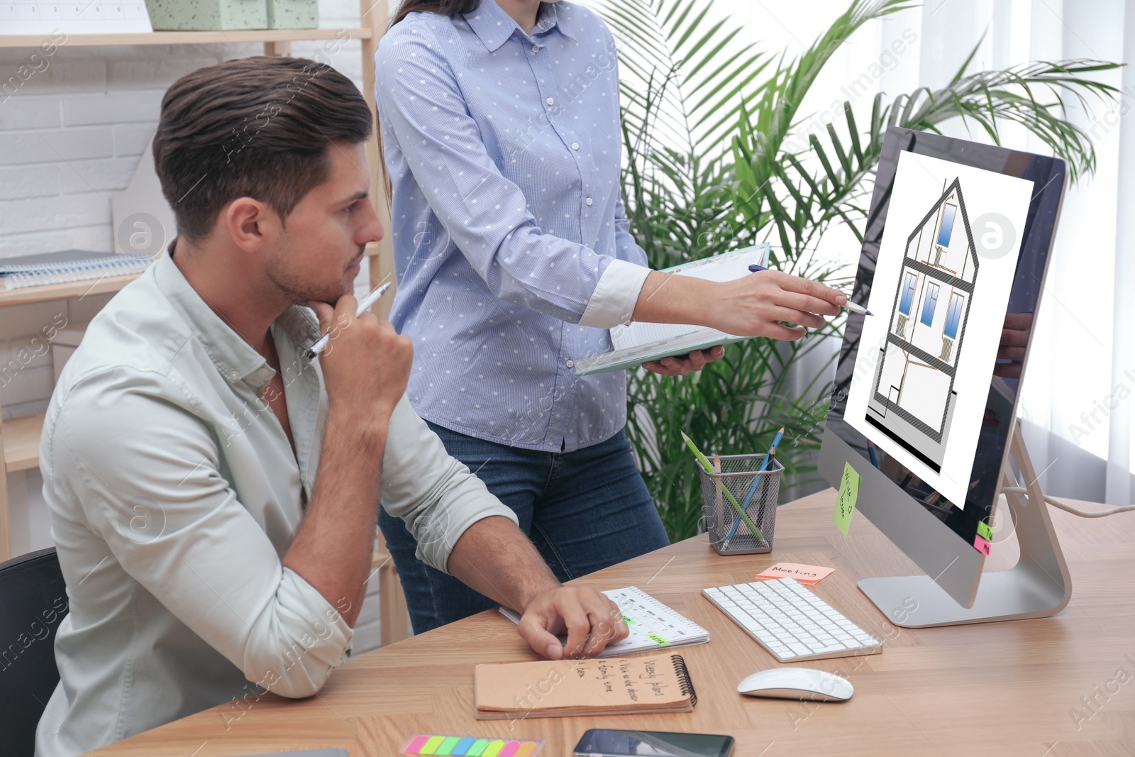 Image of Engineers at work. Colleagues projecting house in office