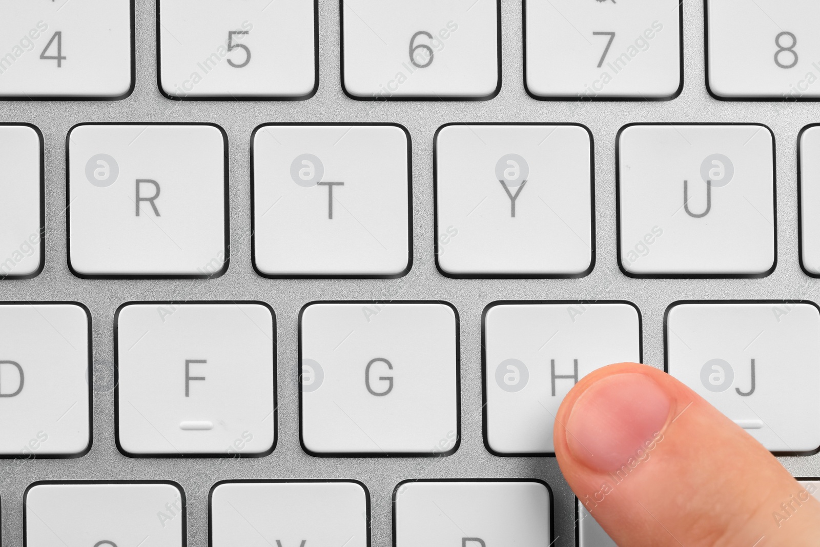 Photo of Top view of man pressing button on computer keyboard, closeup