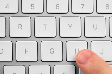 Photo of Top view of man pressing button on computer keyboard, closeup