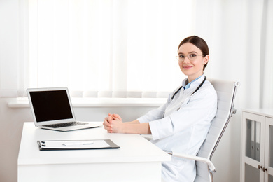 Photo of Portrait of young female doctor in white coat at workplace