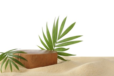 Photo of Presentation of product. Wooden podium and palm leaves on sand against white background