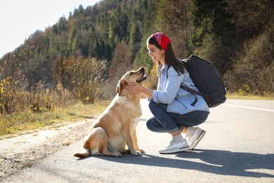 Happy woman and adorable dog on road. Traveling with pet