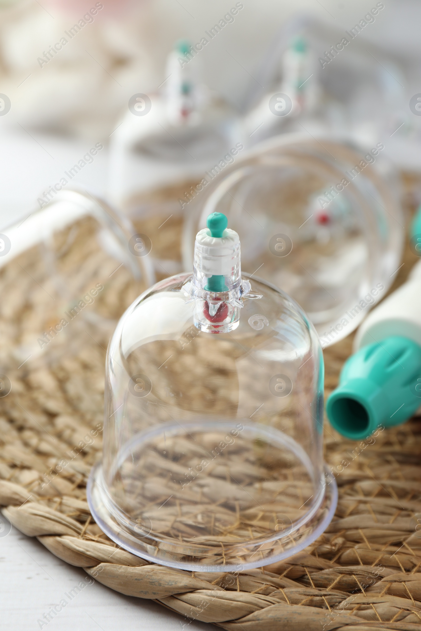 Photo of Plastic cups on white table, closeup. Cupping therapy