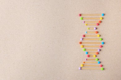 Photo of Model of DNA molecular chain on beige background, top view. Space for text