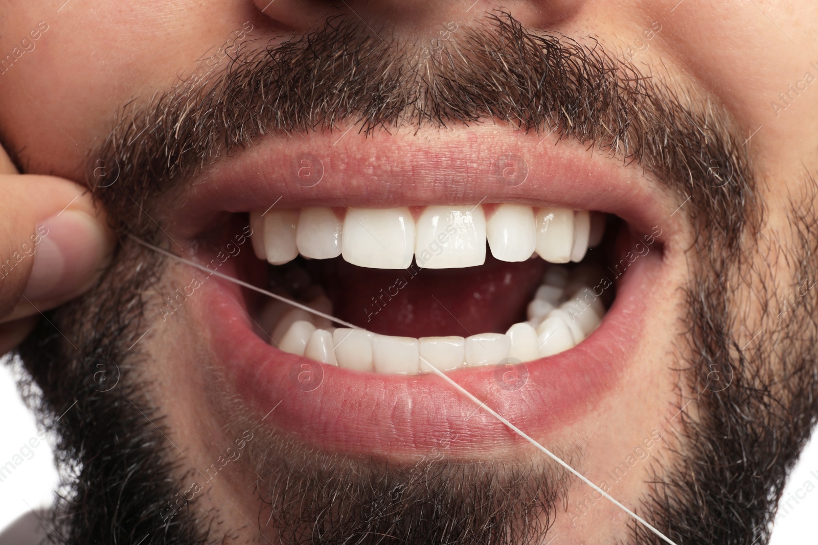 Photo of Man flossing his teeth on white background, closeup. Dental care