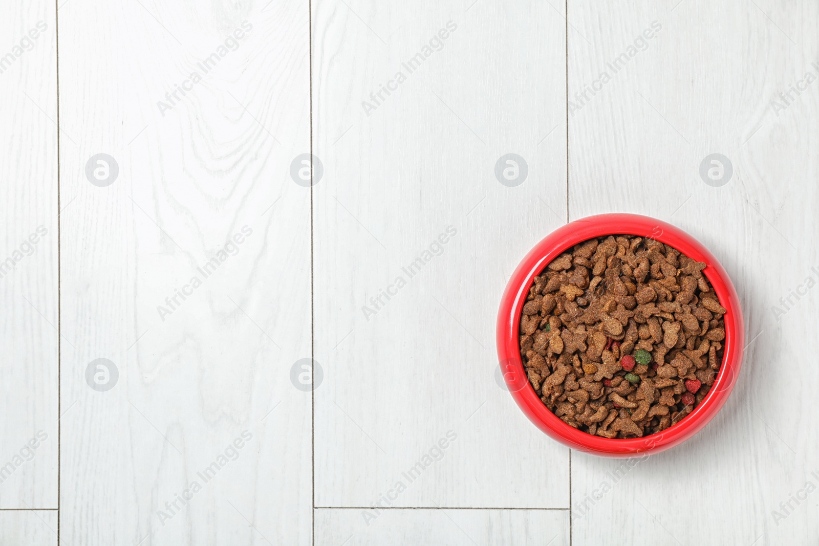 Photo of Bowl with food for cat or dog on wooden background. Pet care