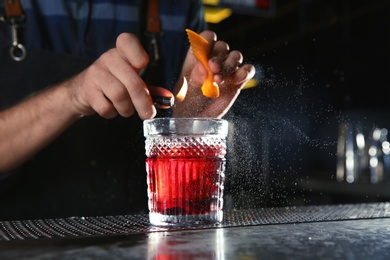 Barman making Red Russian cocktail at counter in pub, closeup. Space for text