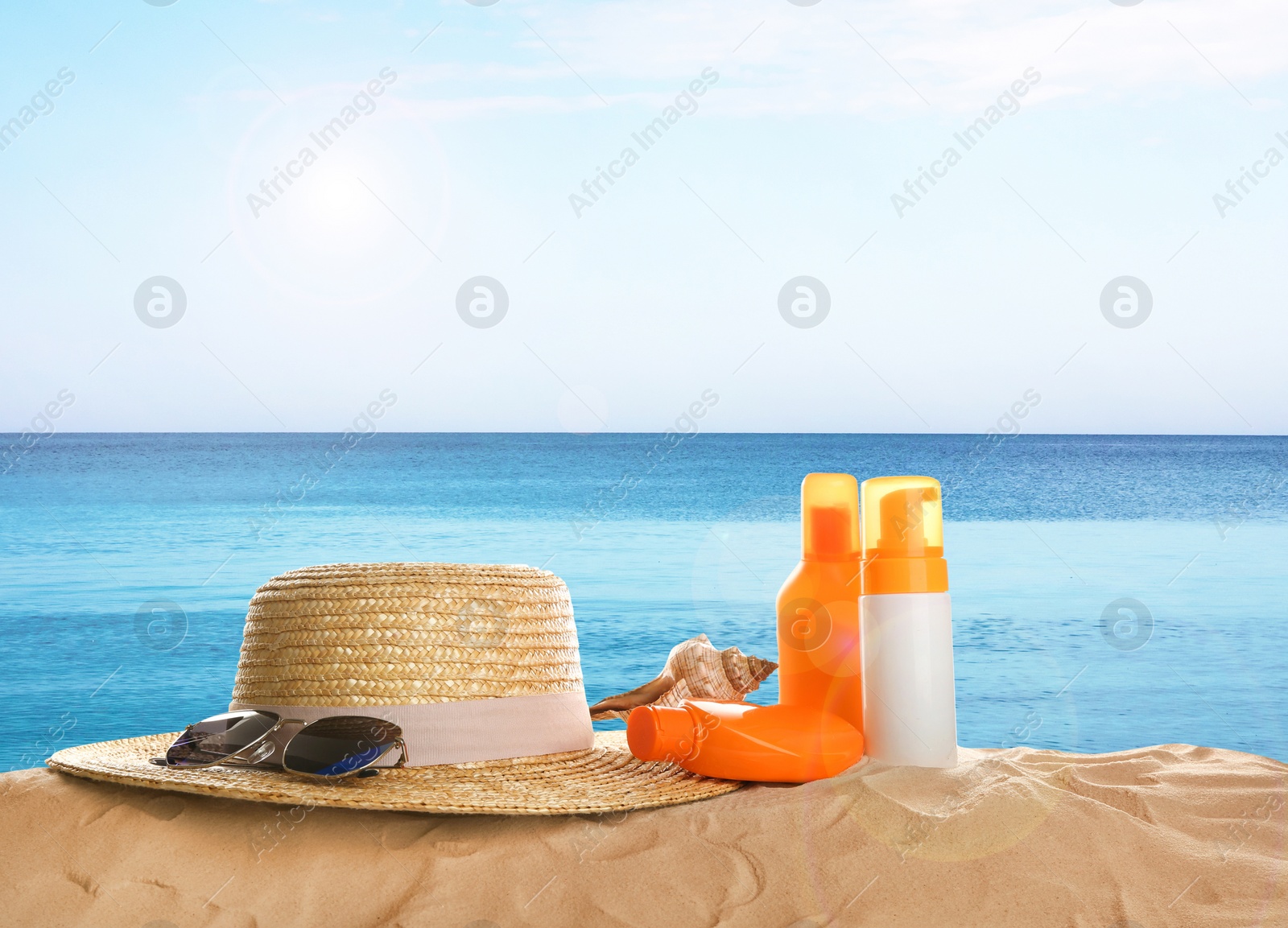 Image of Different beach accessories on sand near sea