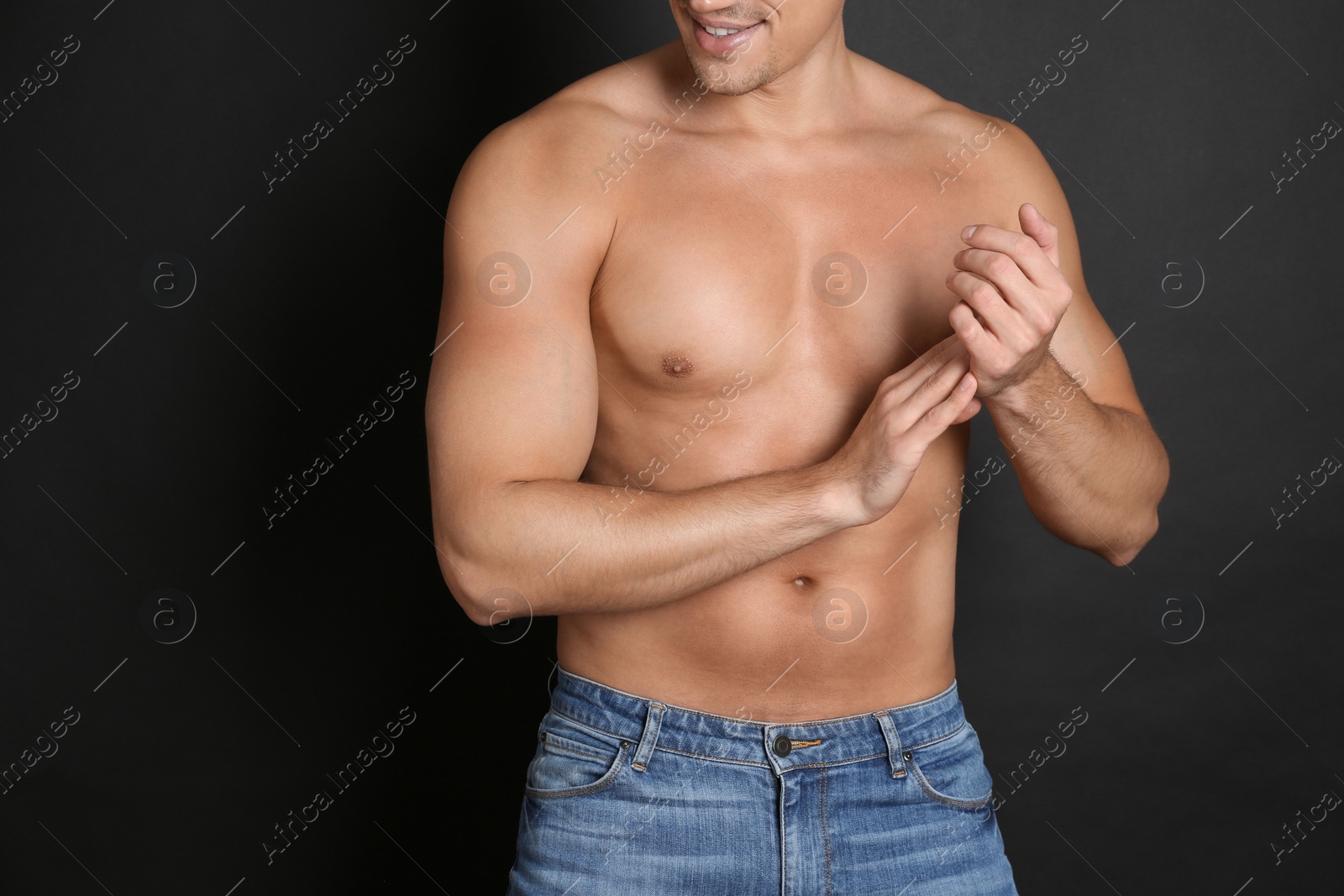 Photo of Man with sexy body on black background, closeup