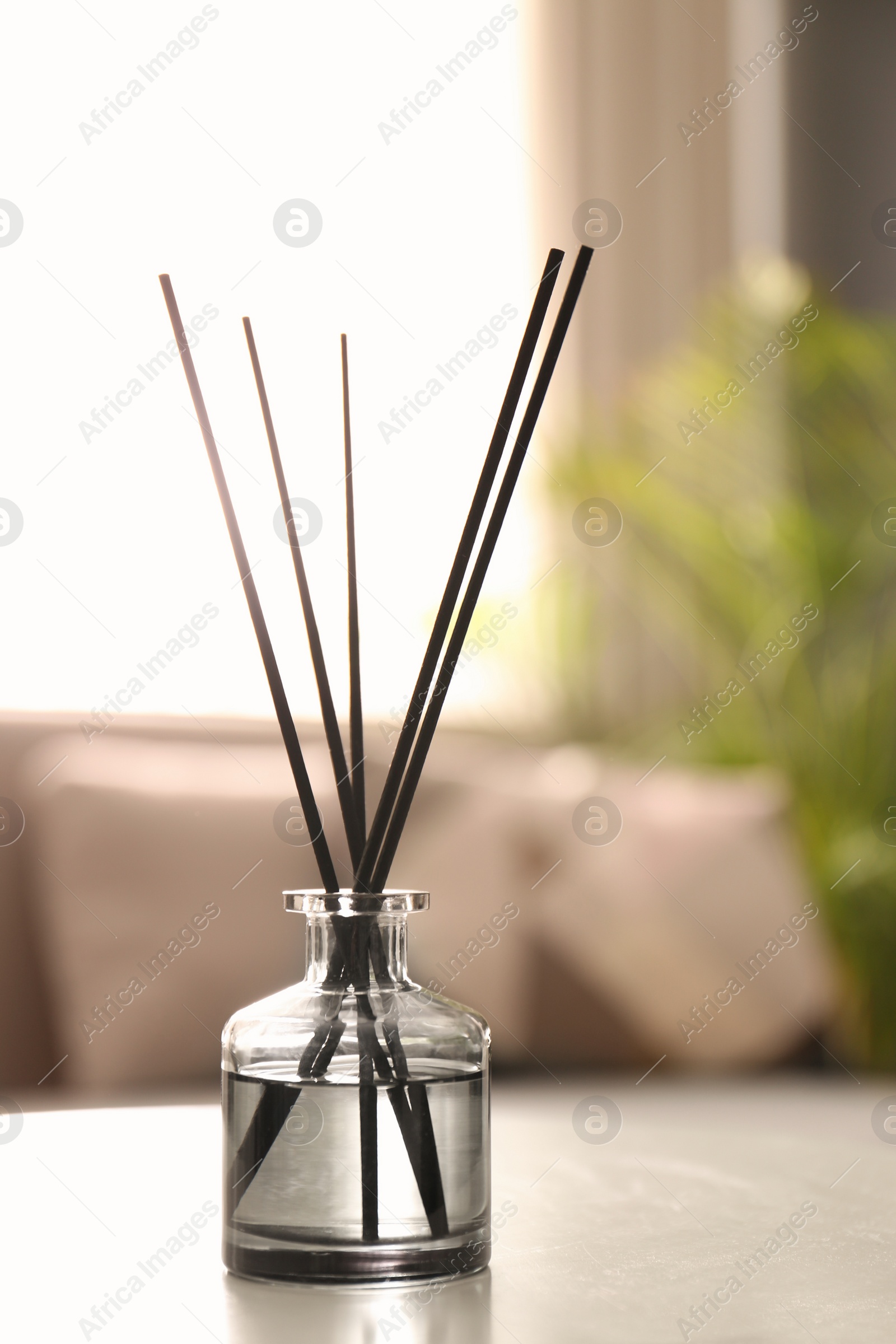 Photo of Aromatic reed air freshener on white table in room