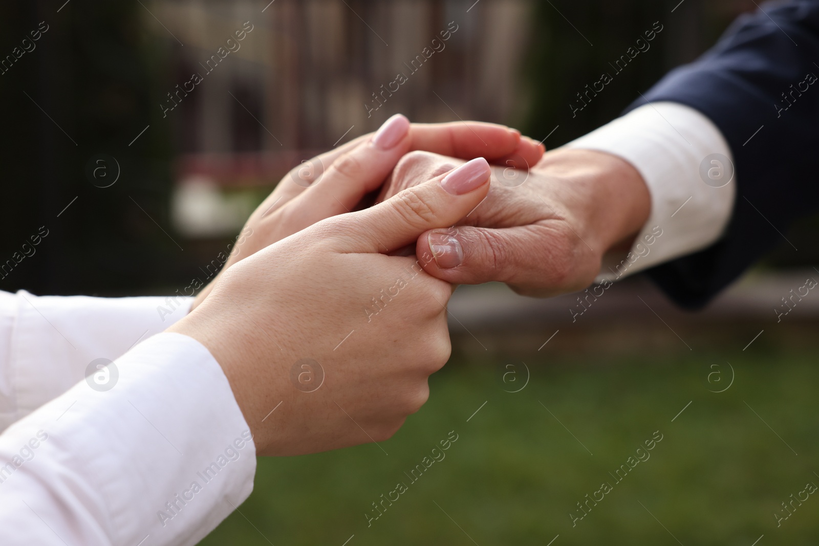 Photo of Trust and deal. Partners joining hands outdoors, closeup