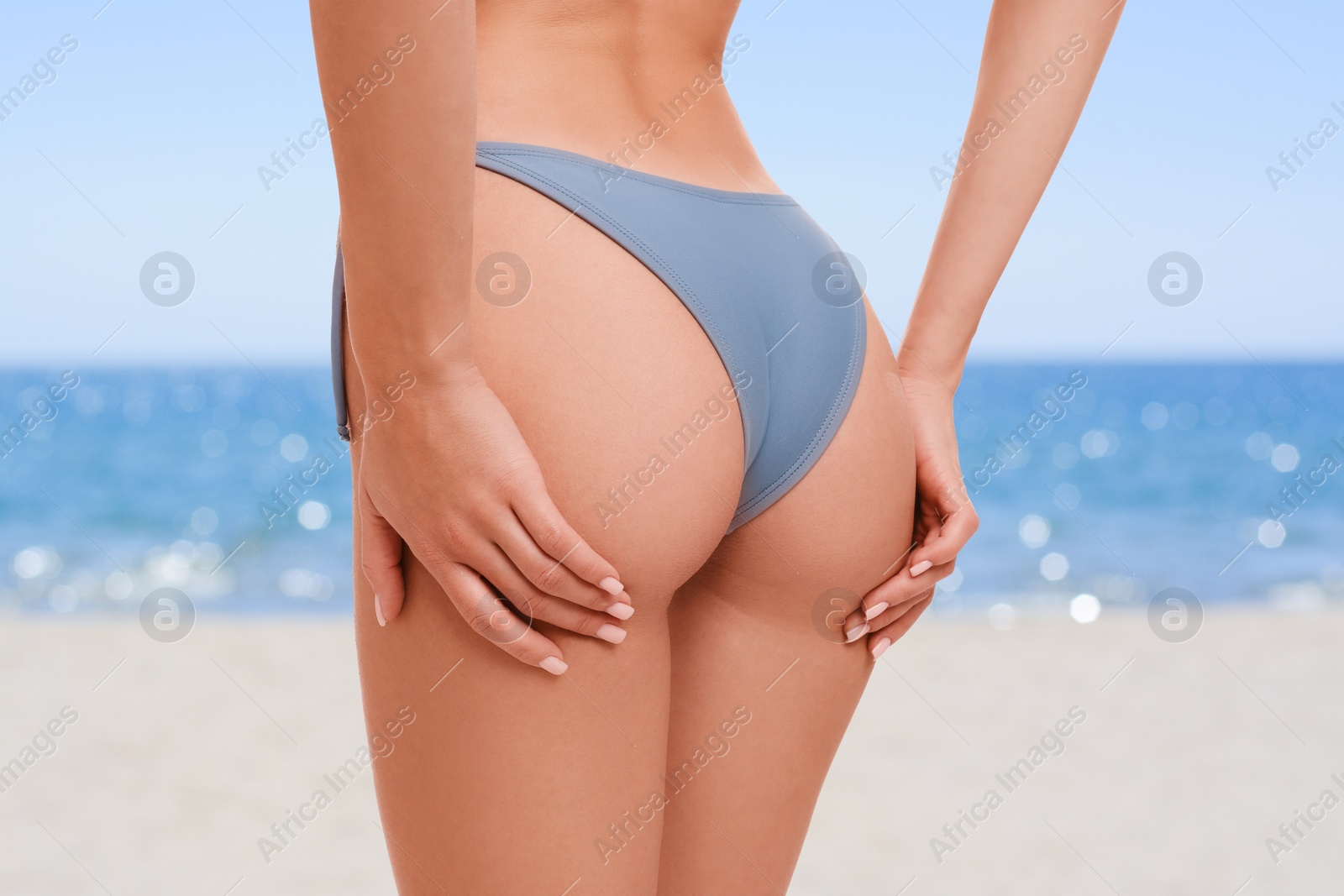 Image of Woman in stylish bikini on sandy beach near sea, closeup