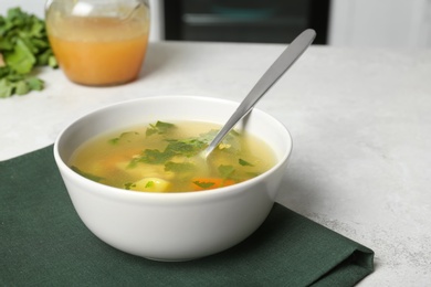 Photo of Bowl with delicious hot broth on table. Cold treatment