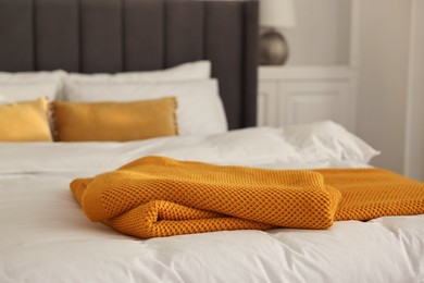 Soft orange plaid on bed in bedroom