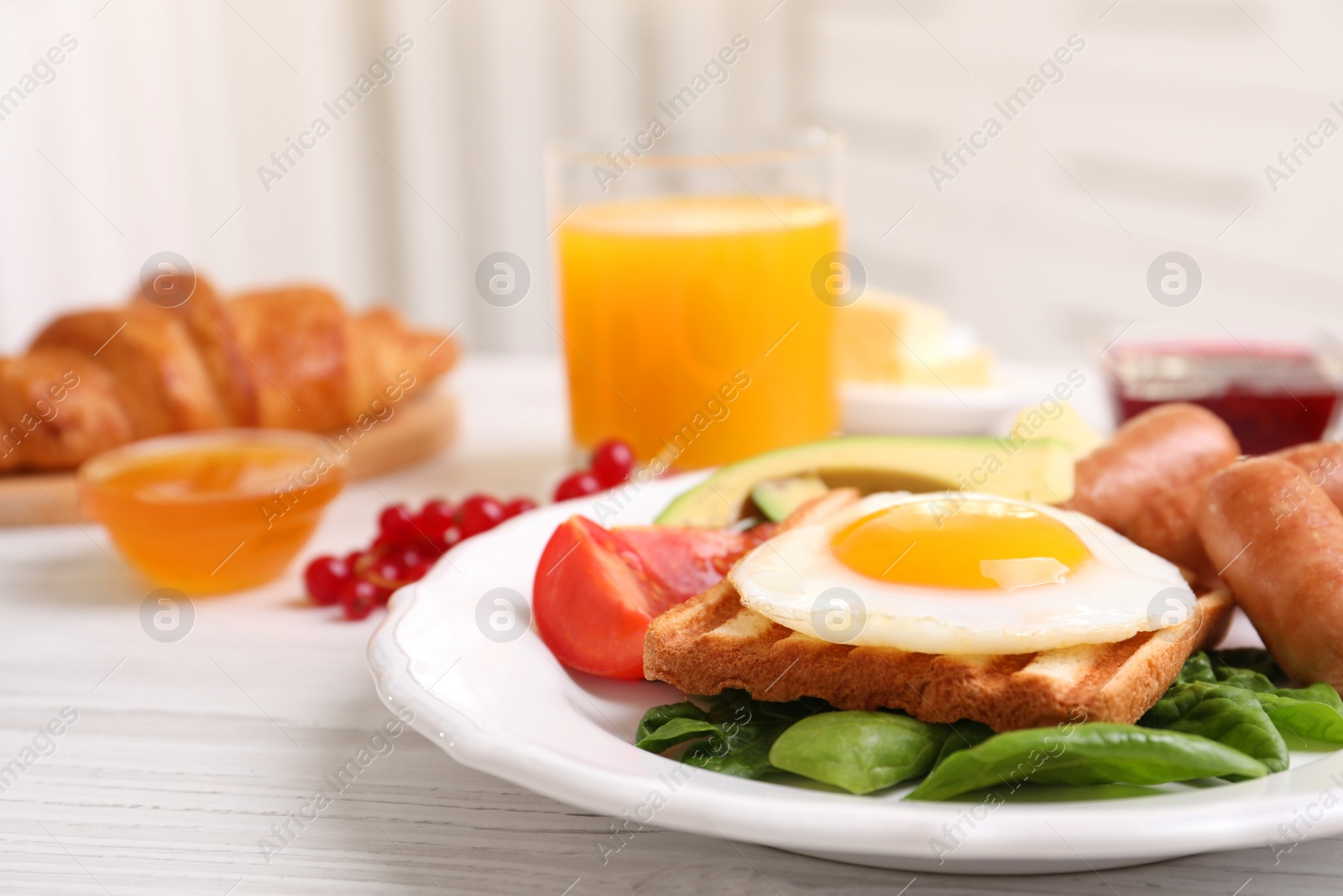 Photo of Delicious breakfast with fried egg on white wooden table, closeup