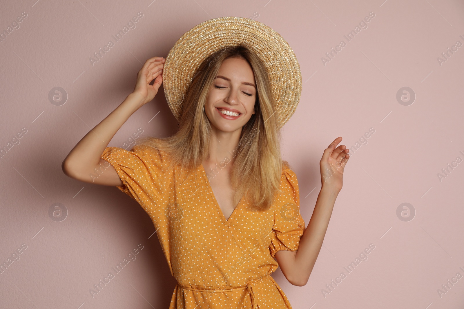 Photo of Young woman wearing stylish dress on pale pink background