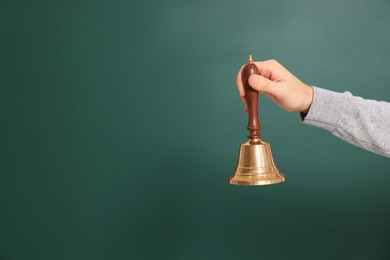 Photo of Teacher with school bell near chalkboard, closeup. Space for text