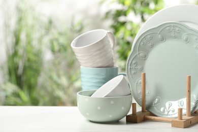 Photo of Beautiful ceramic dishware and cup on white table outdoors, space for text