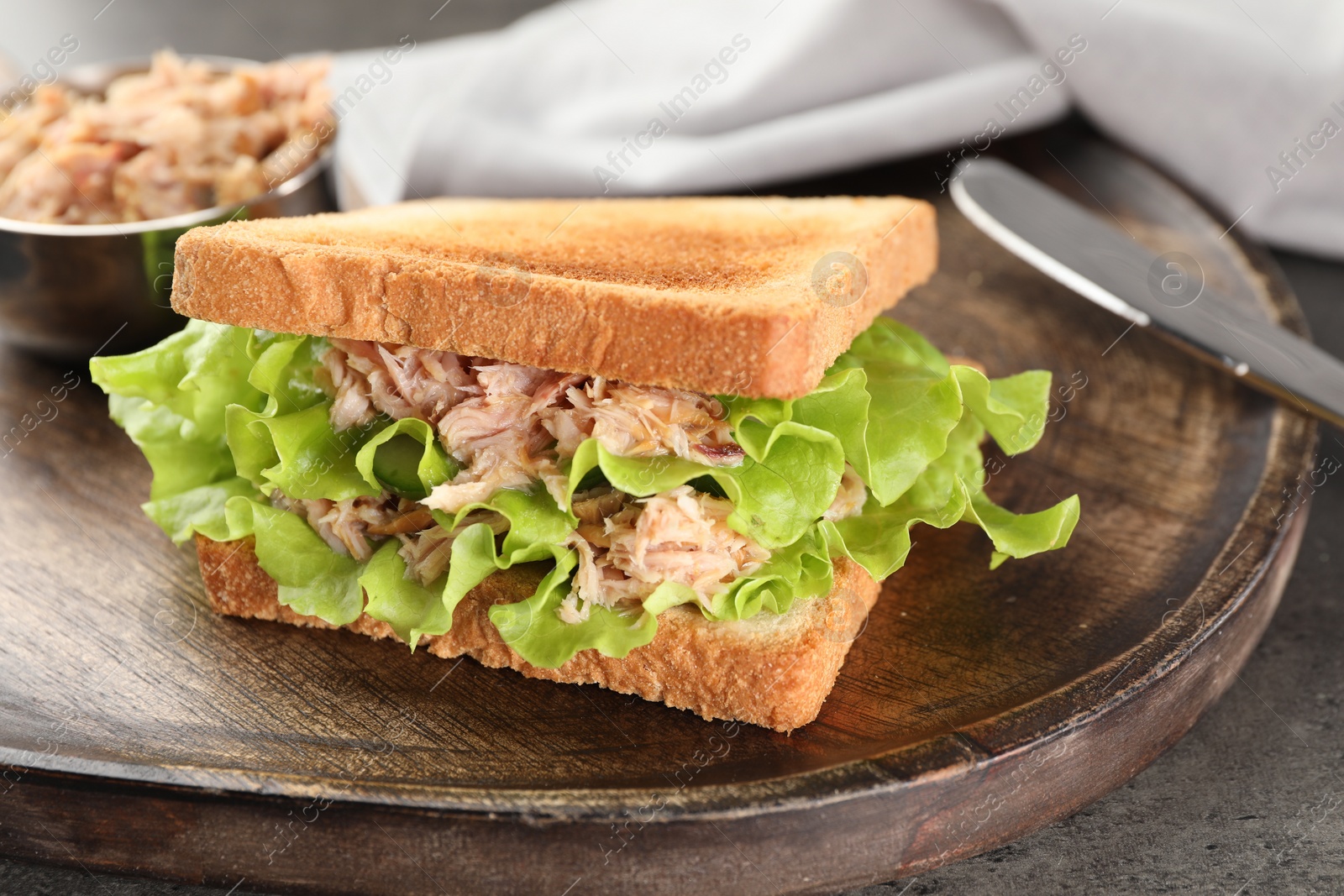 Photo of Delicious sandwich with tuna, lettuce leaves and cucumber on light grey table