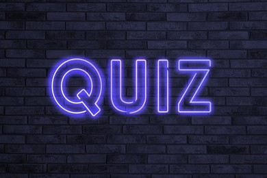 Image of Word QUIZ made of neon letters on black brick background