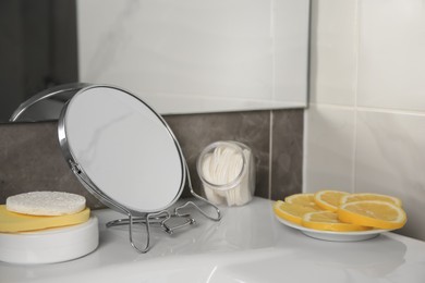 Photo of Lemon face wash. Fresh citrus fruits, personal care products and mirror on sink in bathroom