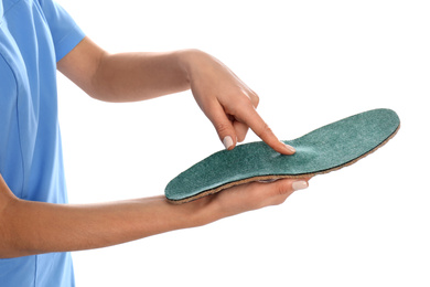 Female orthopedist showing insole on white background, closeup