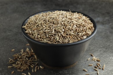 Bowl of caraway seeds on grey table, closeup