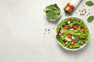 Photo of Delicious salad in bowl on light grey table, flat lay. Space for text