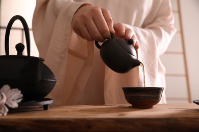 Master conducting traditional tea ceremony at table, closeup