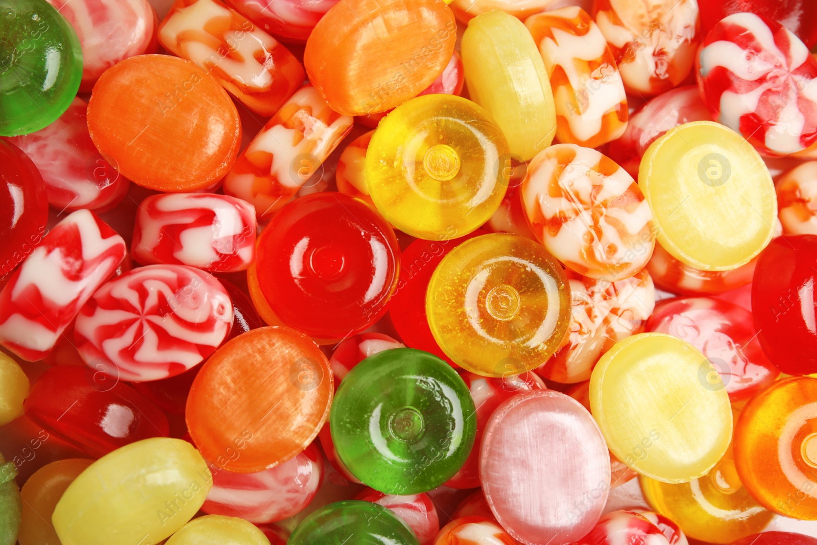 Photo of Different delicious colorful candies as background, top view