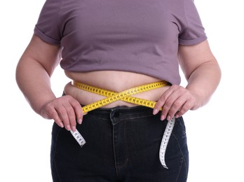 Overweight woman measuring waist with tape on white background, closeup