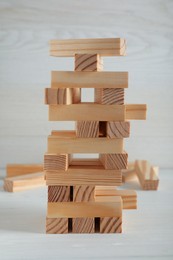 Photo of Jenga tower made of wooden blocks on white table