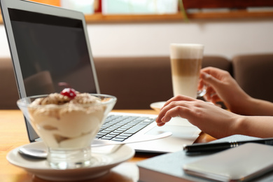 Blogger working with laptop in cafe, closeup