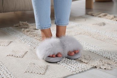 Woman wearing soft slippers at home, closeup of legs