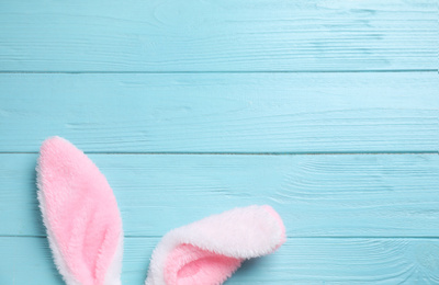 Decorative bunny ears and space for text on light blue wooden background, flat lay. Easter holiday